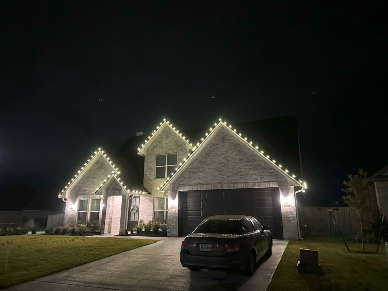 Home with warm white roofline Christmas lights on its front gables - Astro City Lighting