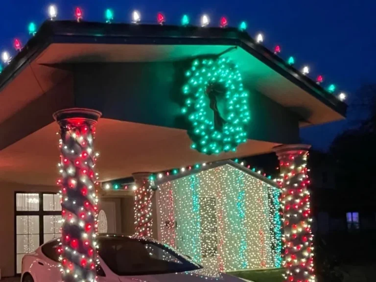 Home with red and green Christmas lights, lighted columns and wreath Home with red and green Christmas lights, lighted columns and wreath
