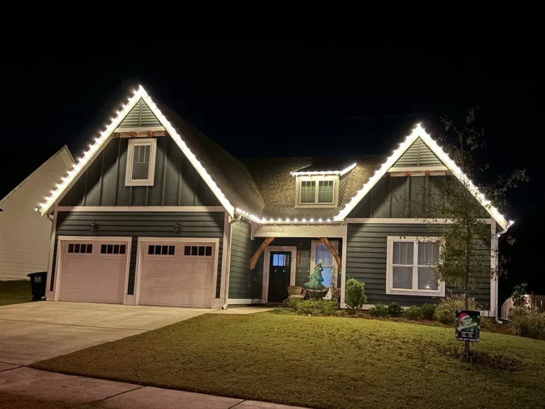 Two-story home with warm white C9 roofline Christmas lights - Kelly Creek Lawn Service