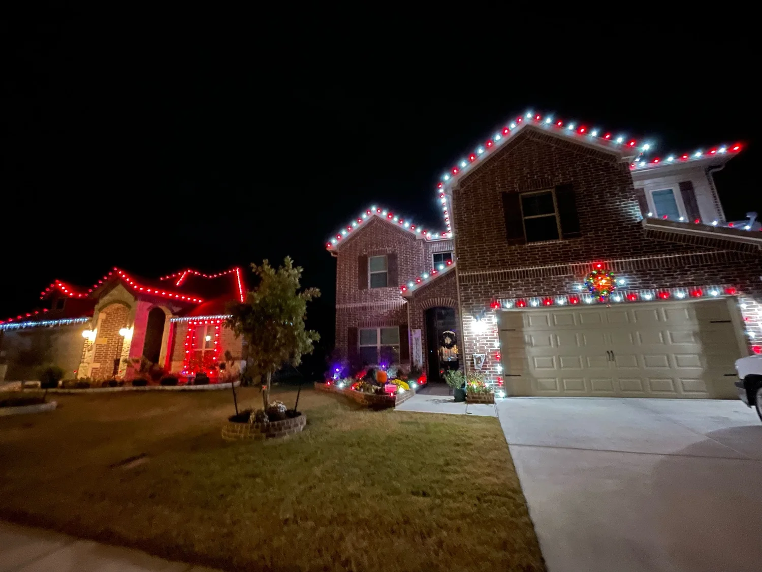 Two-story home with red and white C9 roofline Christmas lights